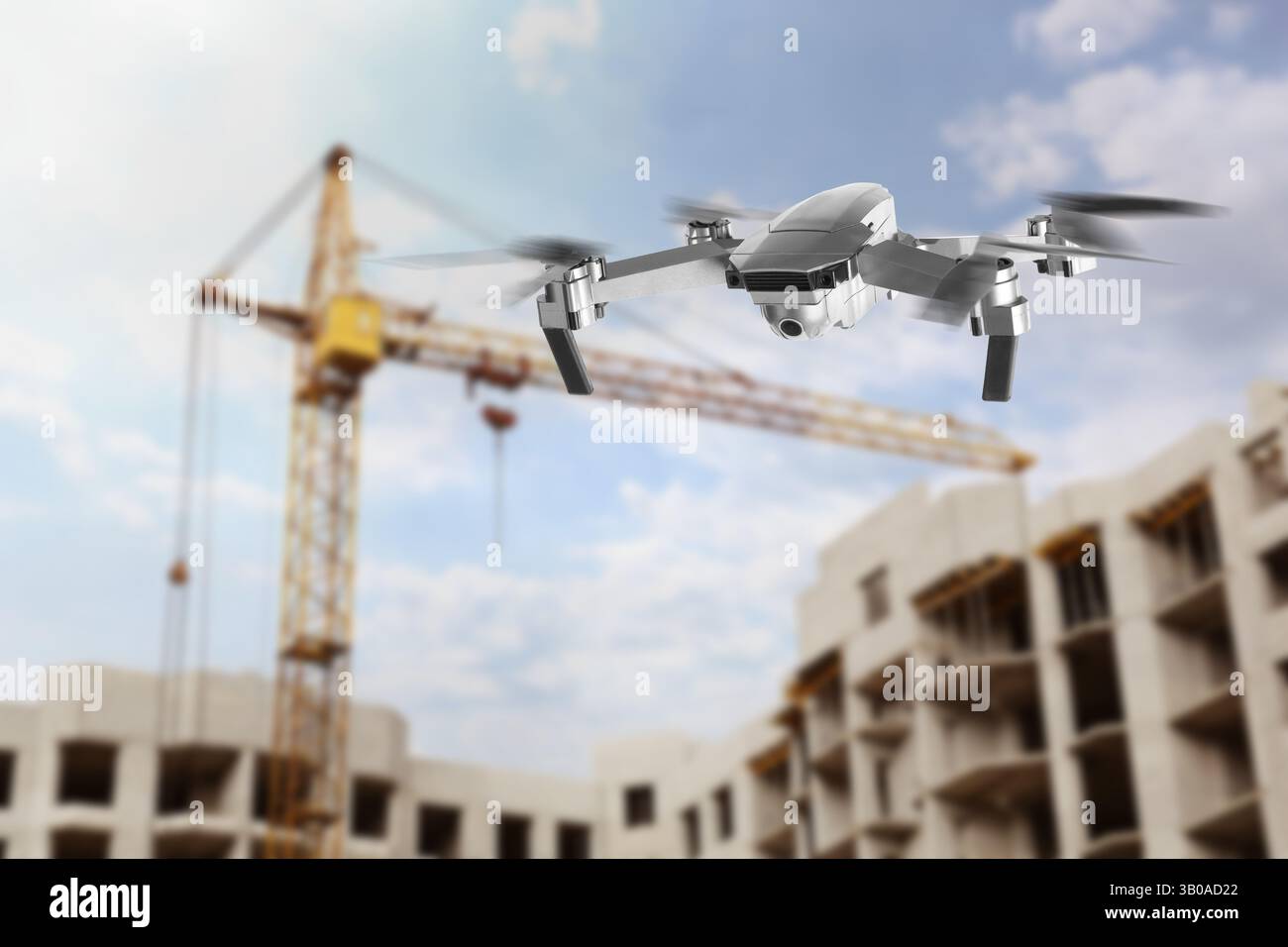 Drone con macchina fotografica che vola vicino a un edificio incompiuto. Veicolo aereo senza equipaggio per la sorveglianza Foto Stock
