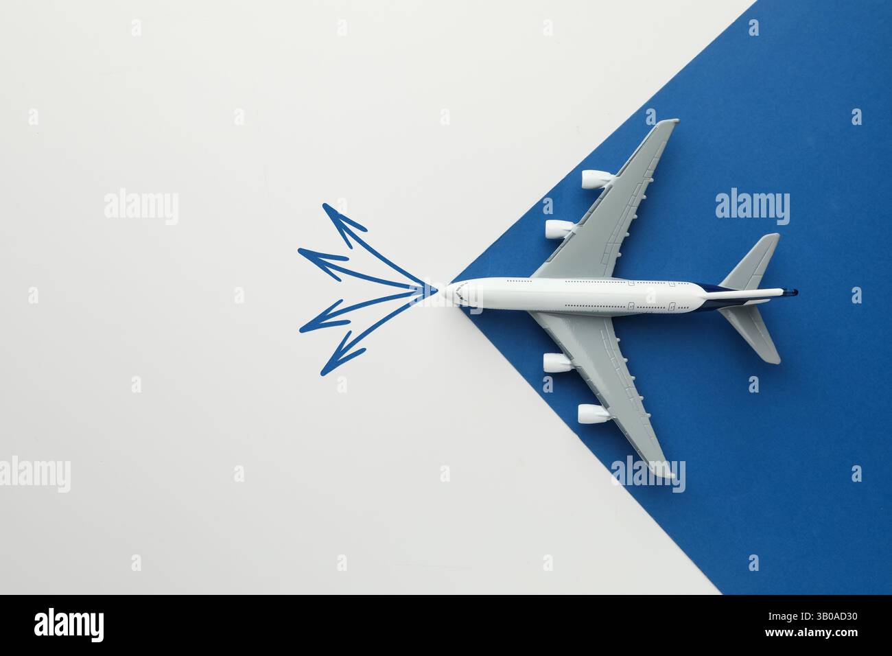 Guida. Frecce che puntano in direzioni diverse davanti all'aereo giocattolo su sfondo colorato, vista dall'alto Foto Stock