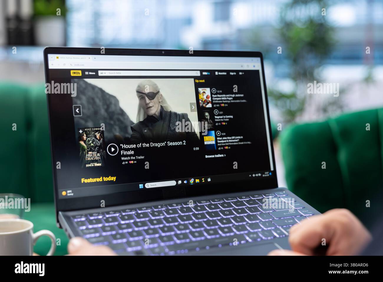 Bucarest, Romania - 30 luglio 2024 - uomo che cerca la pagina online di IMDb per le valutazioni dei film, persona cinefila che guarda un film solo dopo aver letto la recensione della critica o metascore. Elenco degli attori di controllo della ventola. Foto Stock
