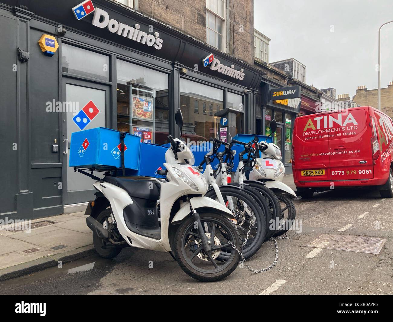 Filiale di Domino's Pizza con scooter per le consegne parcheggiati fuori, Edimburgo, Scozia, Regno Unito - Immagine stock catturata con smartphone