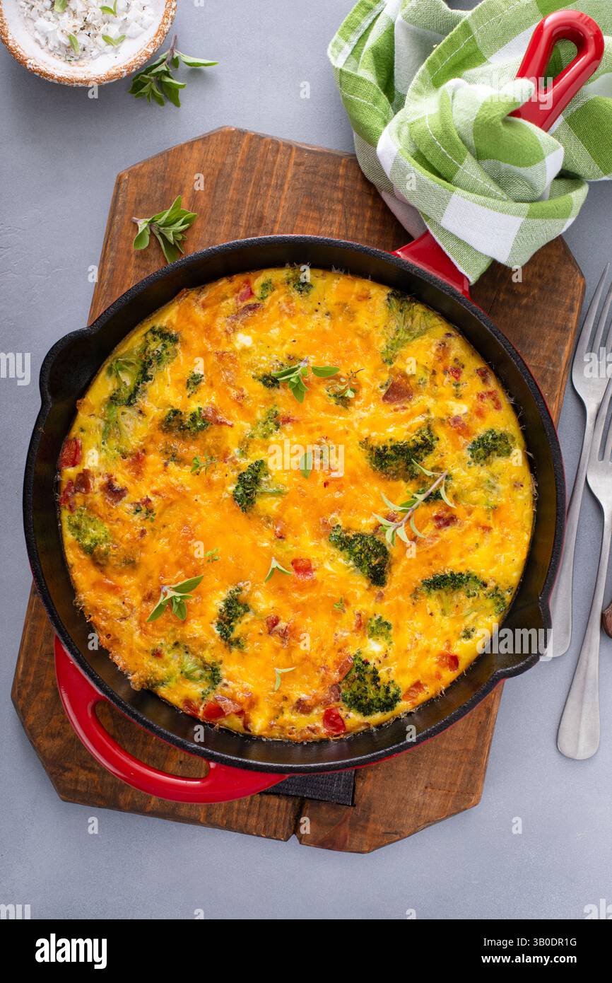 Broccoli, pancetta e frittata di formaggio cotti in una padella di ghisa Foto Stock