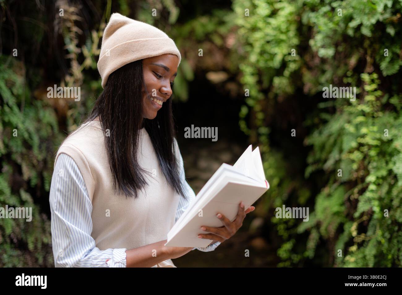 Una donna immersa in un libro circondato dalla bellezza della natura e da un paesaggio tranquillo Foto Stock