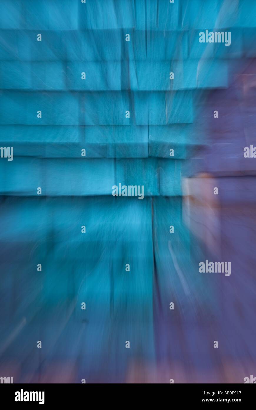 sfocatura astratta con zoom di shingle azzurro chiaro o di cedro sul lato dell'edificio con esposizione prolungata del colore viola e zoom per dare all'immagine una z Foto Stock