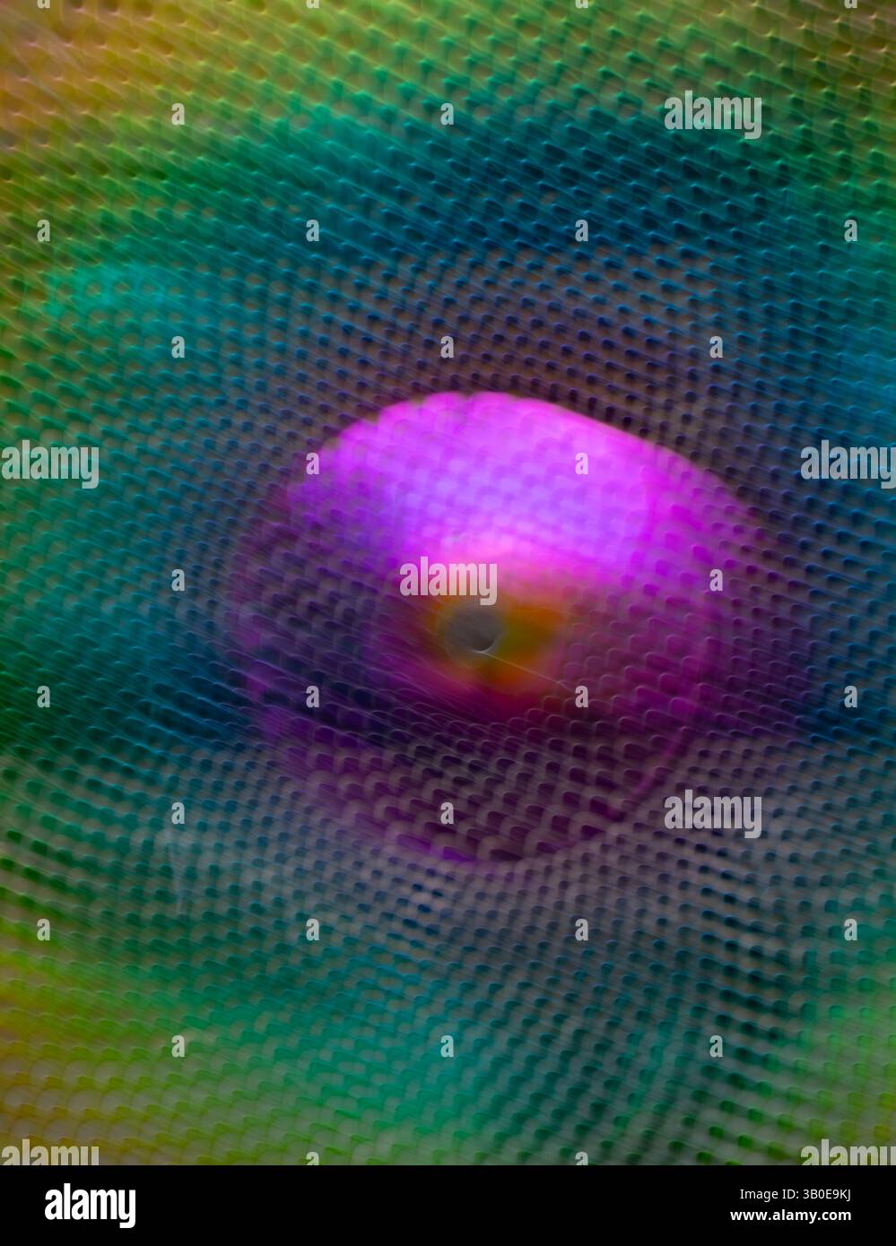 sfocatura astratta della sfera in metallo viola verde e gialla con fori ingranditi con esposizione prolungata e zoom intenzionale dell'obiettivo per creare movimento Foto Stock