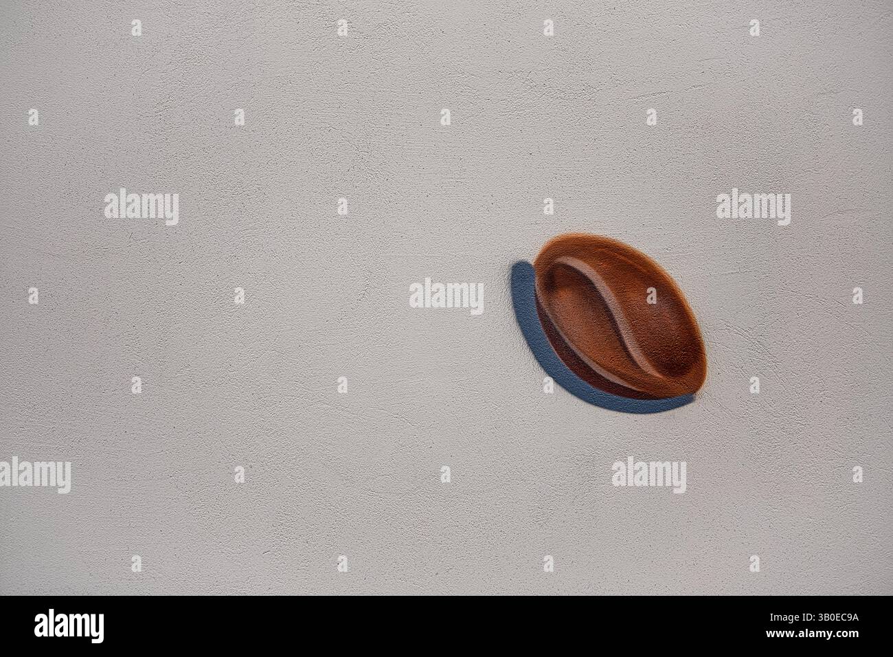 La consistenza della parete di cemento, su cui è dipinta l'immagine dei chicchi di caffè, è pronunciata. Foto Stock