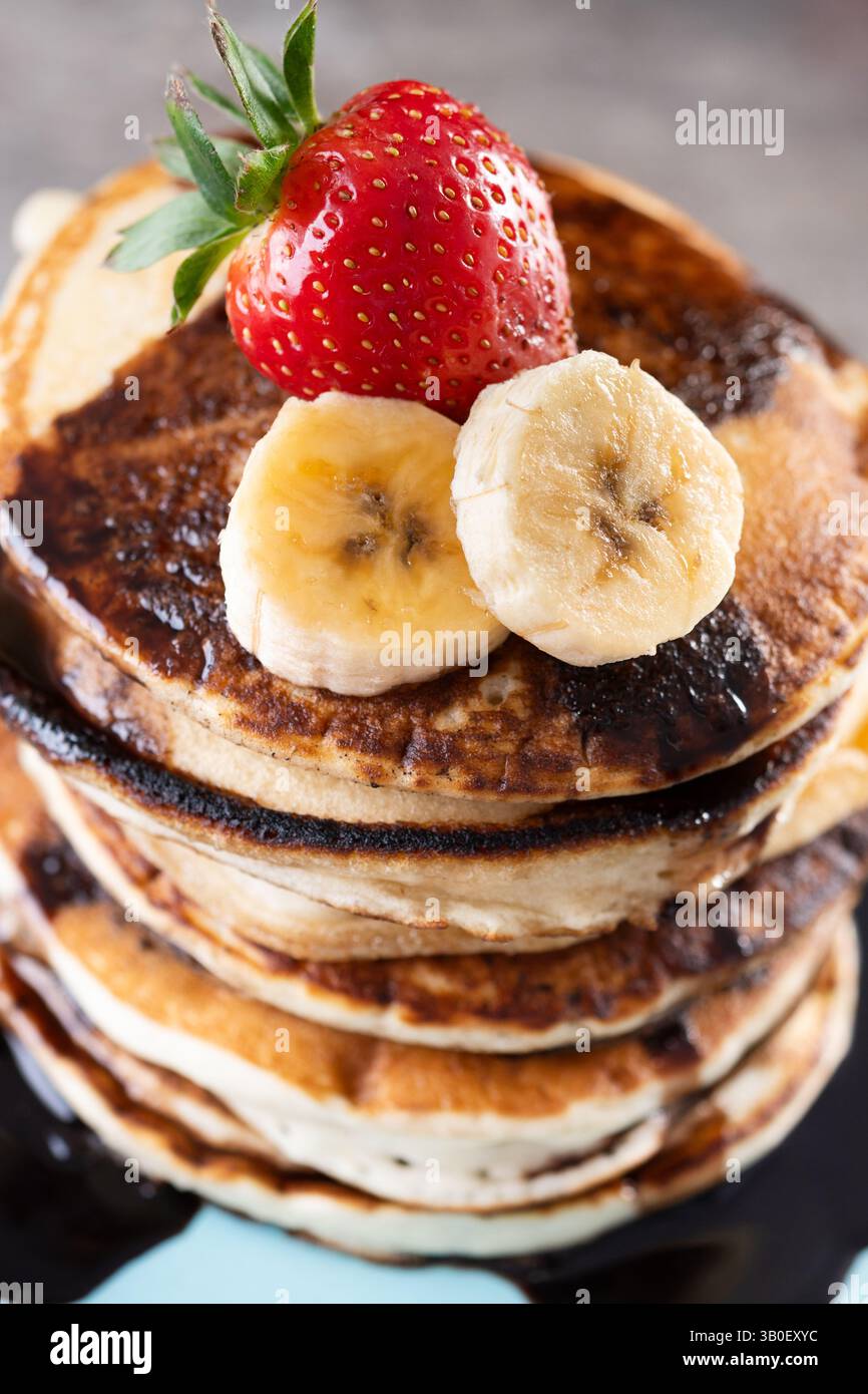 Pancake con cioccolato e frutta su un tavolo di legno Foto Stock