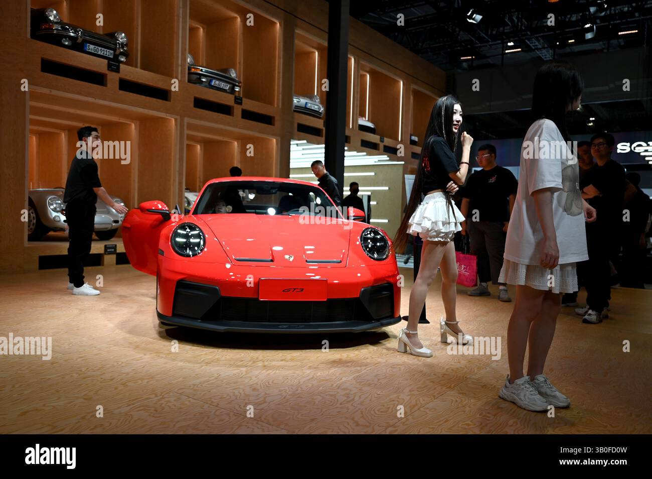 Shanghai, Cina. 24 aprile 2025. Le persone stanno intorno a una Porsche GT 3 in uno stand all'Auto Shanghai. Porsche ha venduto ancora una volta meno veicoli sportivi e fuoristrada all'inizio dell'anno a causa della crisi in Cina e ora si sta concentrando su una maggiore individualità nel segmento premium. Credito: Johannes Neudecker/dpa/Alamy Live News Foto Stock