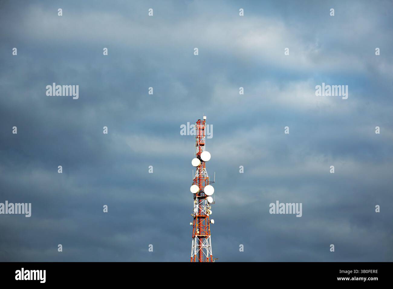 Torre per telecomunicazioni con antenne contro un cielo nuvoloso. Foto Stock