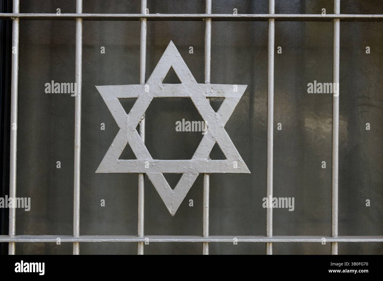 Una stella ebraica decorativa, bianca e metallizzata di David montata sulla griglia della finestra di una casa a Gerusalemme, Israele. Foto Stock