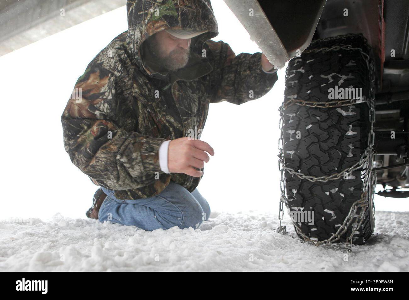 29 dicembre 2010 - Flagstaff, Arizona, Stati Uniti - STUART VALENA lavora per fissare catene da neve al suo camion sotto il cavalcavia all'uscita Kachina Village sull'Interstate 17 mercoledì mattina. Valena è venuta a Flagstaff per prendere sua moglie in modo che non si separassero da una tempesta invernale che si stava spostando nella zona.. (Immagine di credito: © Jake Bacon/Arizona Daily Star/ZUMAPRESS.com) Foto Stock