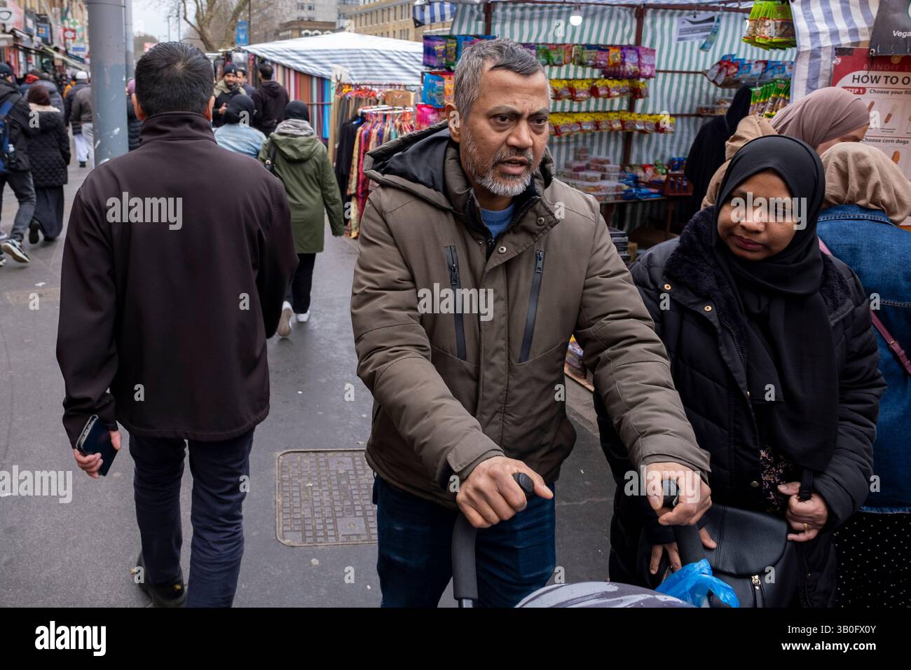 A soli 5 giorni dalla fine del Ramadan, il mercato di Whitechapel e' pieno di attivita' il 25 marzo 2025 a Londra, Regno Unito. Whitechapel è un quartiere etnicamente diversificato e vivace nell'East End, che ospita una significativa popolazione di residenti del Bangladesh. Questo può essere visto lungo i marciapiedi dove il mercato di Whitechapel e i negozi circostanti interagiscono con questa società veramente multiculturale. Foto Stock