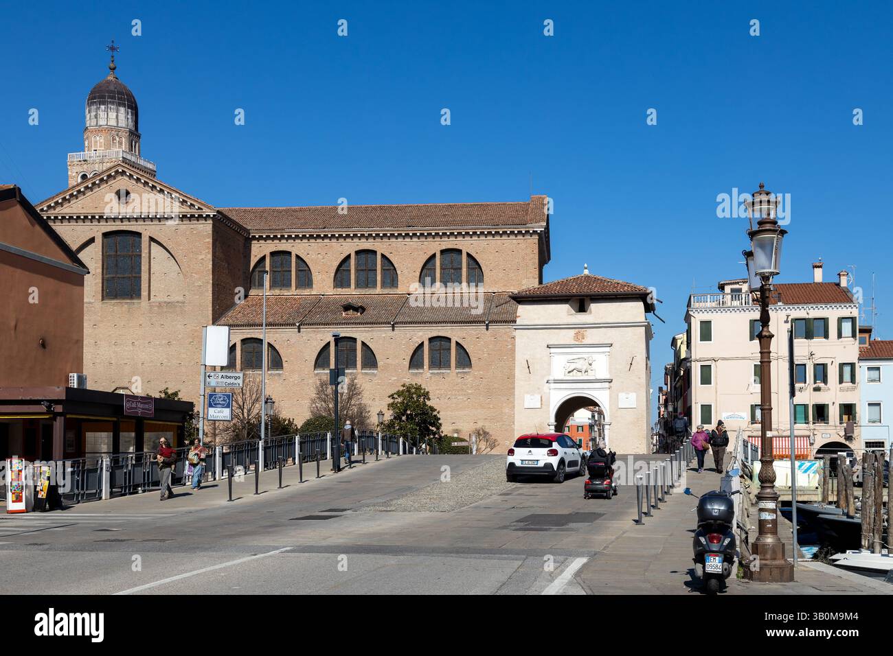 Chioggia, Italia - 3 marzo 2025: Porta Garibaldi e il Duomo, con gente che cammina nel centro storico della città Foto Stock