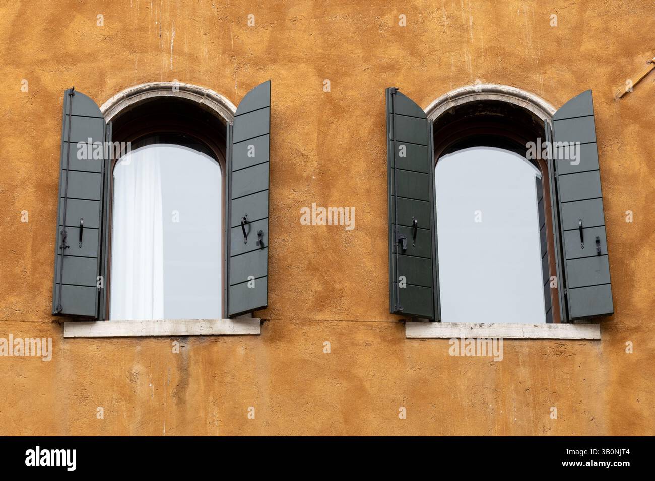 Due finestre ad arco con otturatori verdi Foto Stock