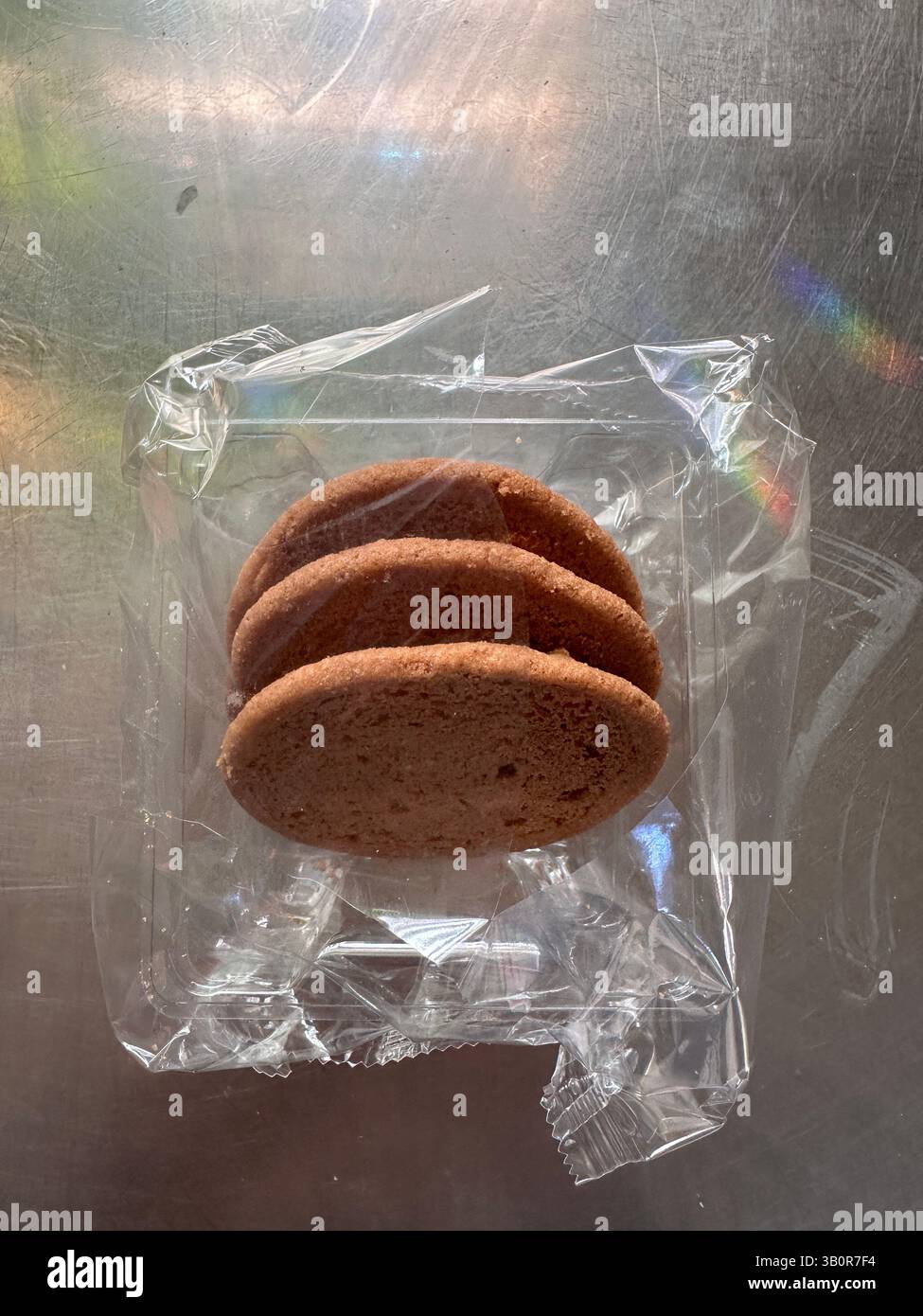 3 biscotti sul tavolo da cucina ancora in una confezione di plastica Foto Stock