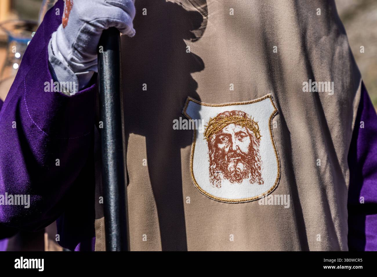 Partecipa a una processione religiosa spagnola, indossando un mantello con un'immagine di Gesù. Paseo del Jucar, Cuenca, Castilla-la Mancha, Spagna Foto Stock
