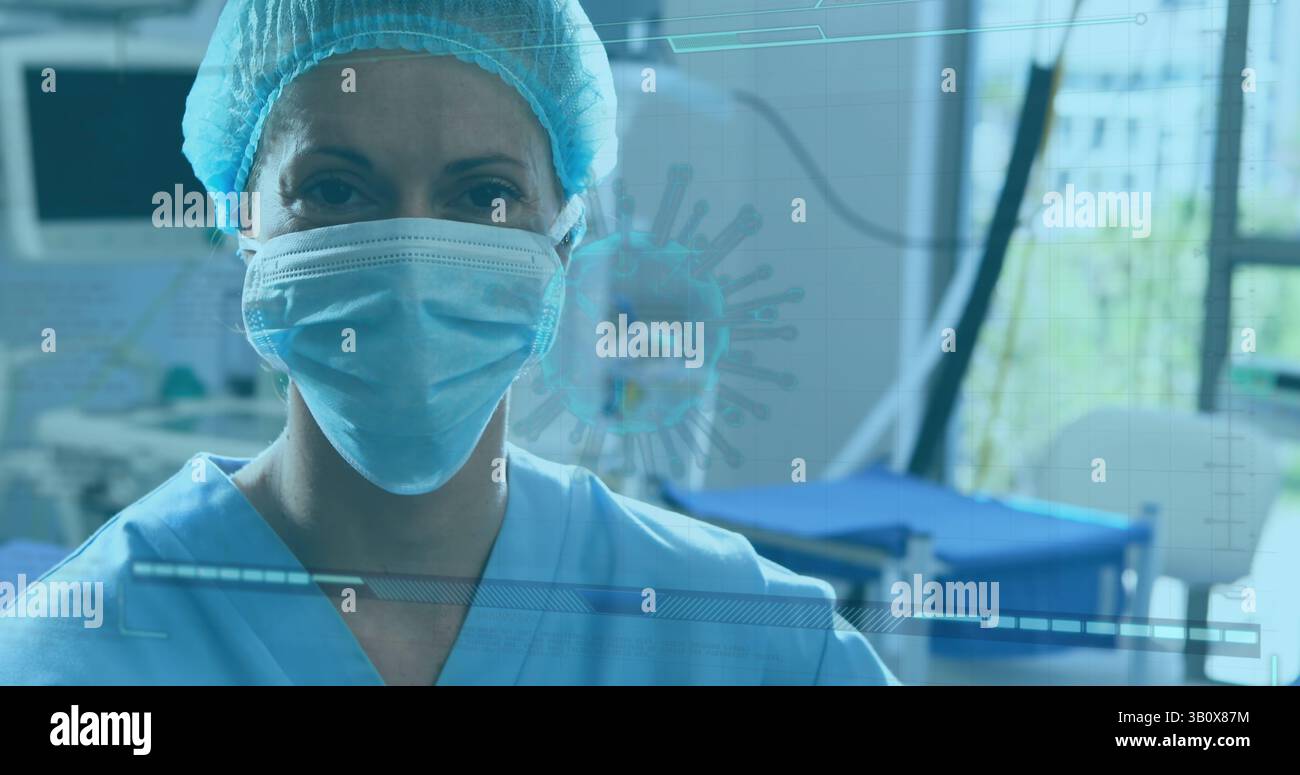 Lavoratore in piedi che indossa scrub blu, cappuccio e maschera nella sala di trattamento, con monitor, sovrapposizione di virus Foto Stock