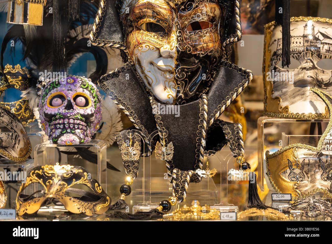 Venezia, Italia - 17 aprile 2025: Esposizione di elaborate maschere veneziane e teschio d'arte nella vetrina del negozio locale Foto Stock
