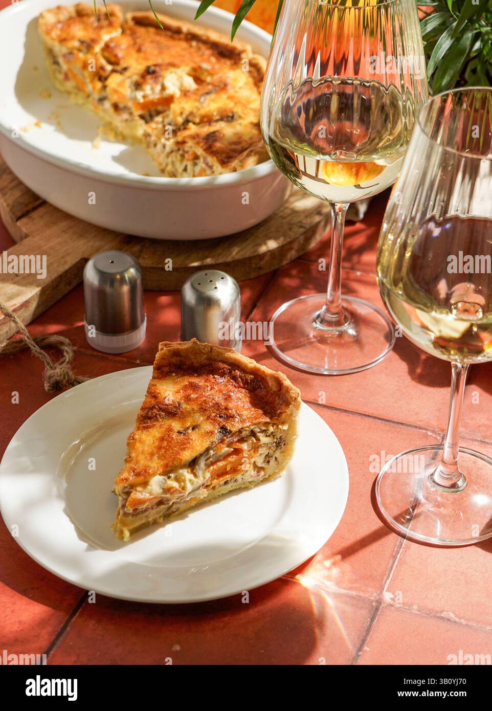 quiche di zucca e pancetta su pasta frolla. con funghi ostrici, luce solare dura. piastrelle in ceramica Foto Stock