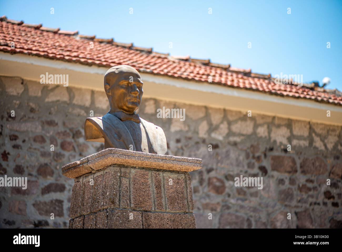 Una visione rispettosa e simbolica dell’effigie di Mustafa Kemal Atatürk posta di fronte a una scuola elementare, che riflette il suo ruolo nel plasmare l’educazione moderna Foto Stock