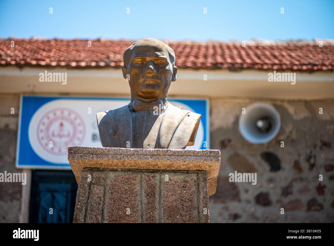 Una visione rispettosa e simbolica dell’effigie di Mustafa Kemal Atatürk posta di fronte a una scuola elementare, che riflette il suo ruolo nel plasmare l’educazione moderna Foto Stock