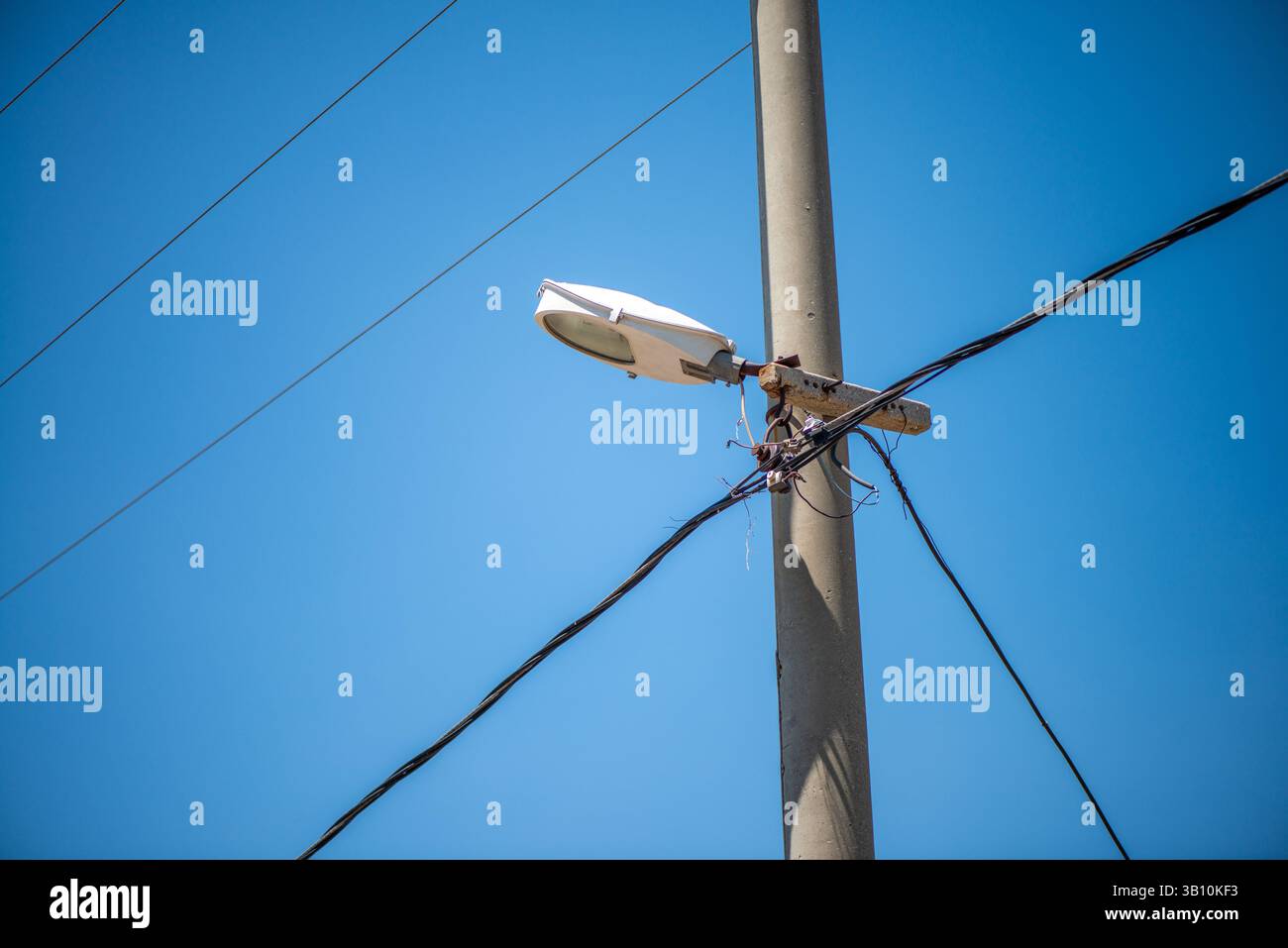 Una scena vibrante che cattura l'energia elettrica della vita urbana: Le luci luminose della città si intrecciano con una rete di cavi sospesi nel cielo notturno. Foto Stock