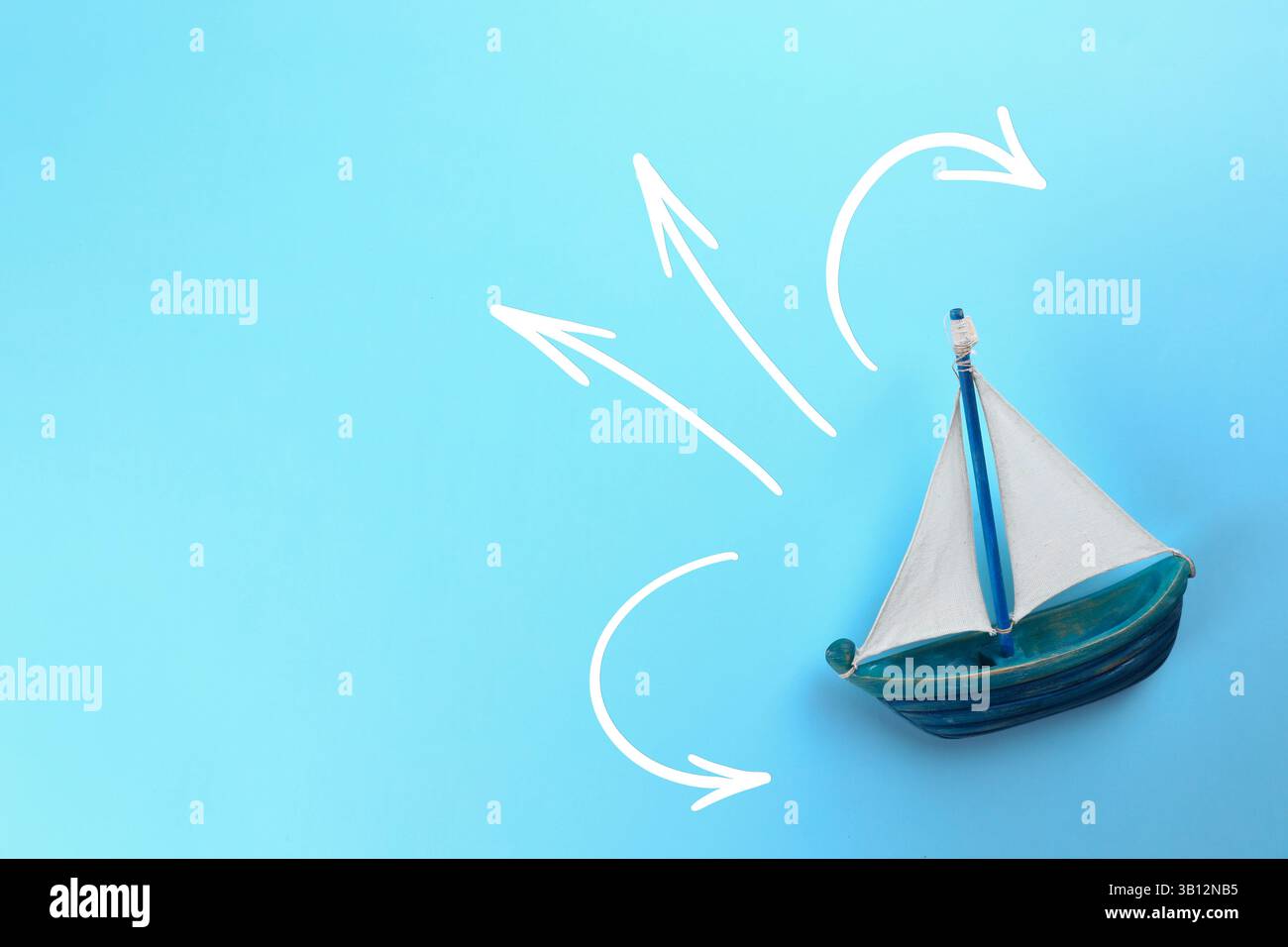 Guida. Frecce che puntano in direzioni diverse davanti alla nave giocattolo su sfondo azzurro, vista dall'alto Foto Stock