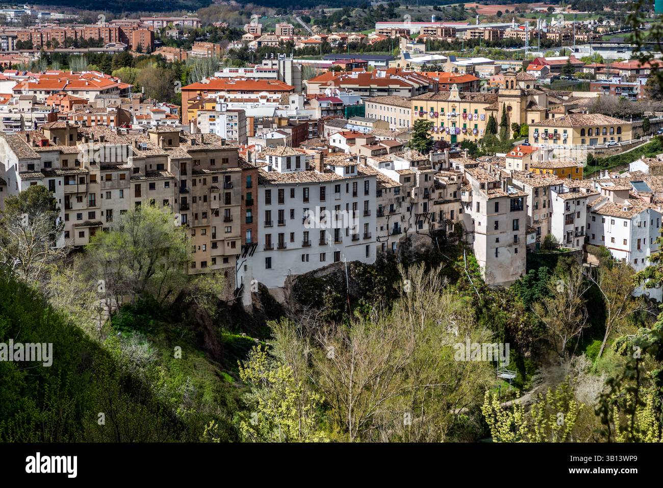 La nuova città di Cuenca, Castilla-La Mancha, Spagna, con l'Ospedale di Santiago e lo stadio di calcio Joaquín Caparrós Camino, si trova oltre la valle del Río Júcar. I tetti dalle tegole rosse della città vecchia si trovano in primo piano, mentre lo sviluppo moderno si estende lungo il lato opposto della valle. Foto Stock