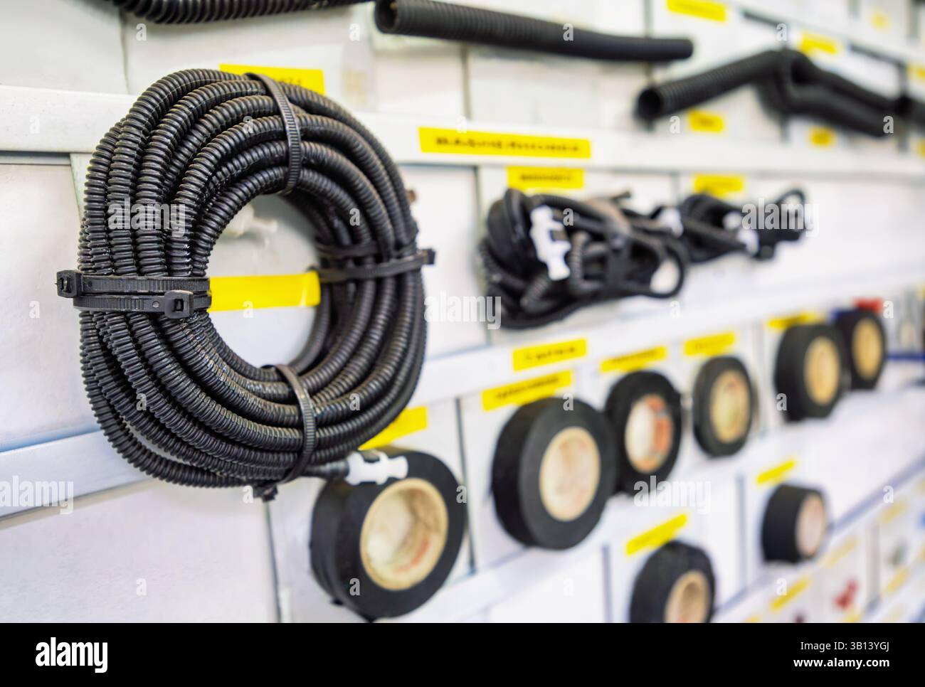 fabbrica di cablaggi per auto, rotolo di tubo corrugato in filo e nastro isolante su un pannello display Foto Stock