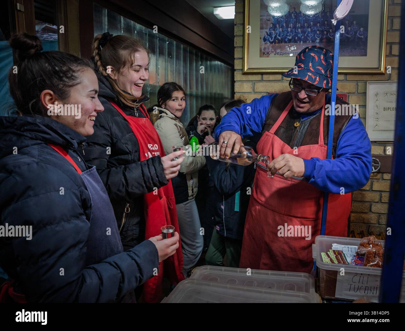 KACAREVO, SERBIA - 22 FEBBRAIO 2025: Contadini serbi, commercianti di un mercato, bevono insieme rakija, un tipico brandy di prugna chiamato sljivovica, wh Foto Stock