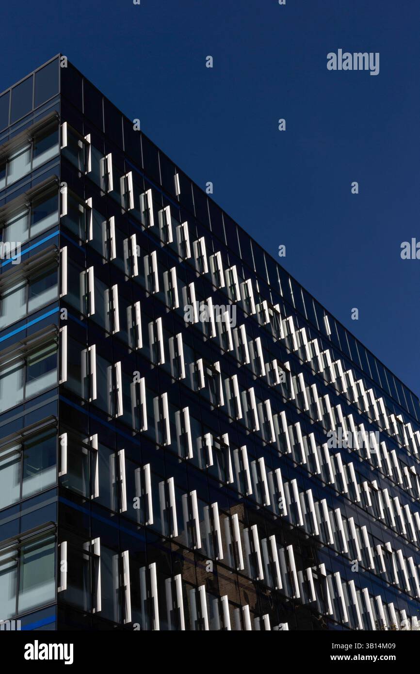 LONDRA, Regno Unito - 1 APRILE 2025: Immagine astratta delle finestre sull'edificio Aldgate High Street 33 nella City di Londra isolato contro il cielo blu Foto Stock