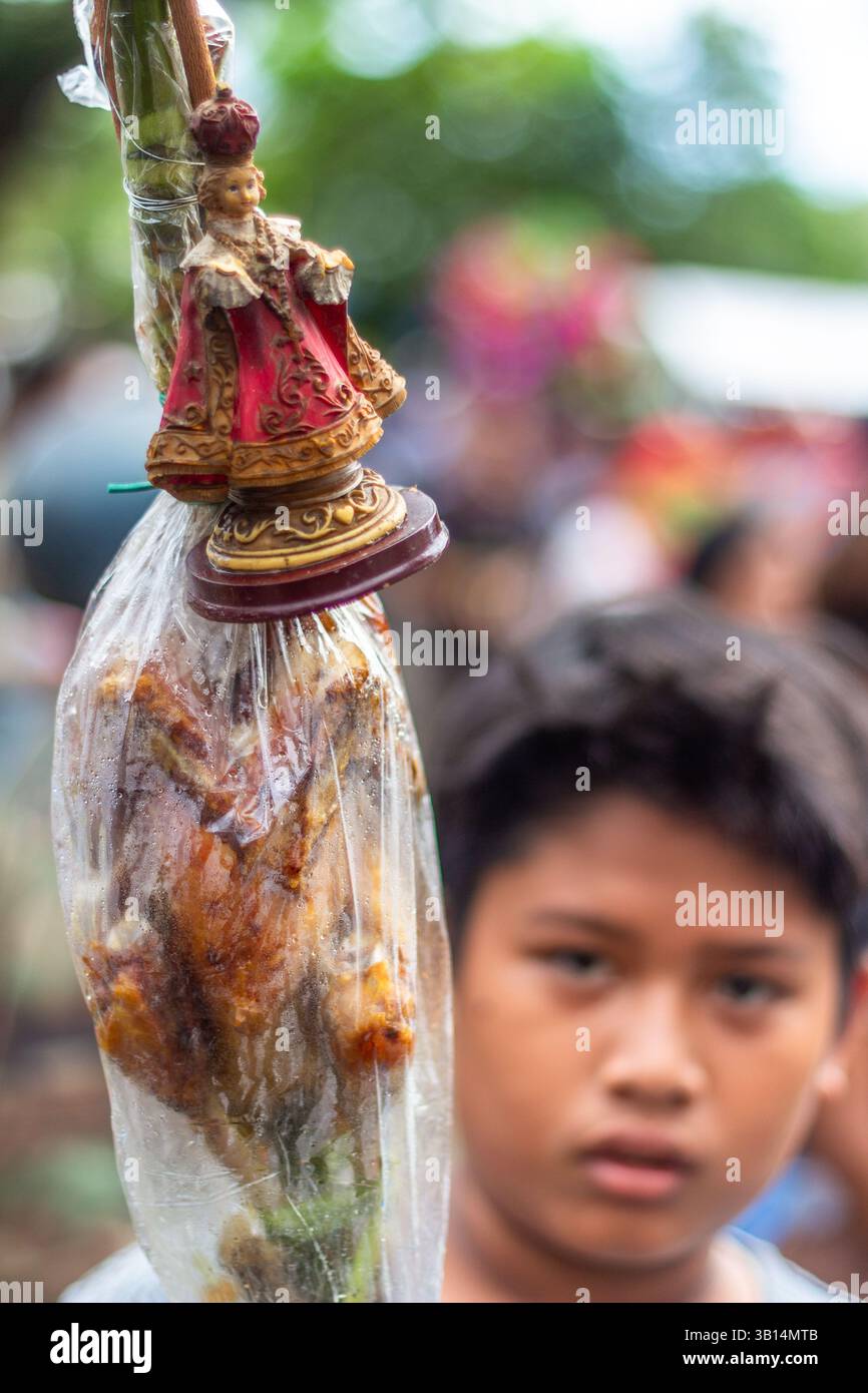 I devoti filippini hanno un'immagine dello sto Niño durante il Festival Ibajay ATI-ATI di Aklan, una vibrante festa religiosa locale nelle Filippine Foto Stock
