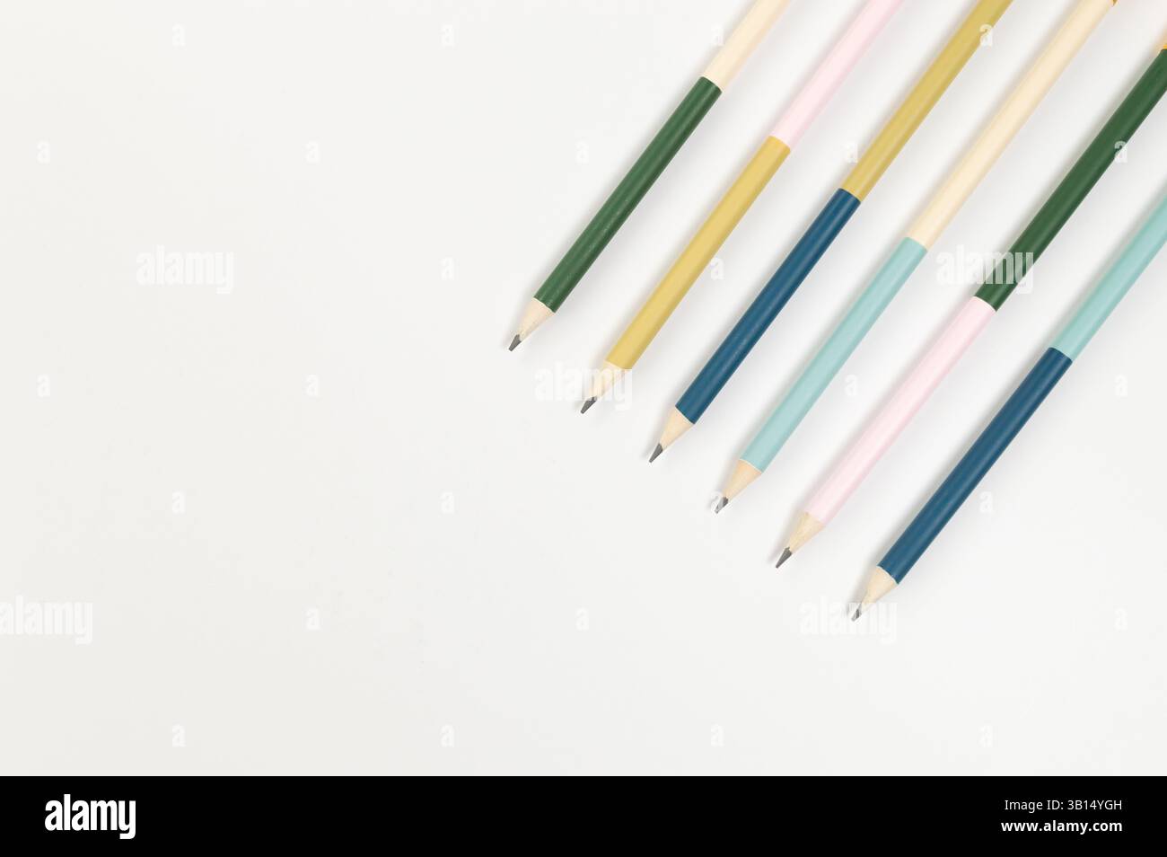 Vista dall'alto delle matite colorate su sfondo bianco. Scuola, ufficio, carta da parati. Disposizione piatta, spazio di copia. Foto Stock