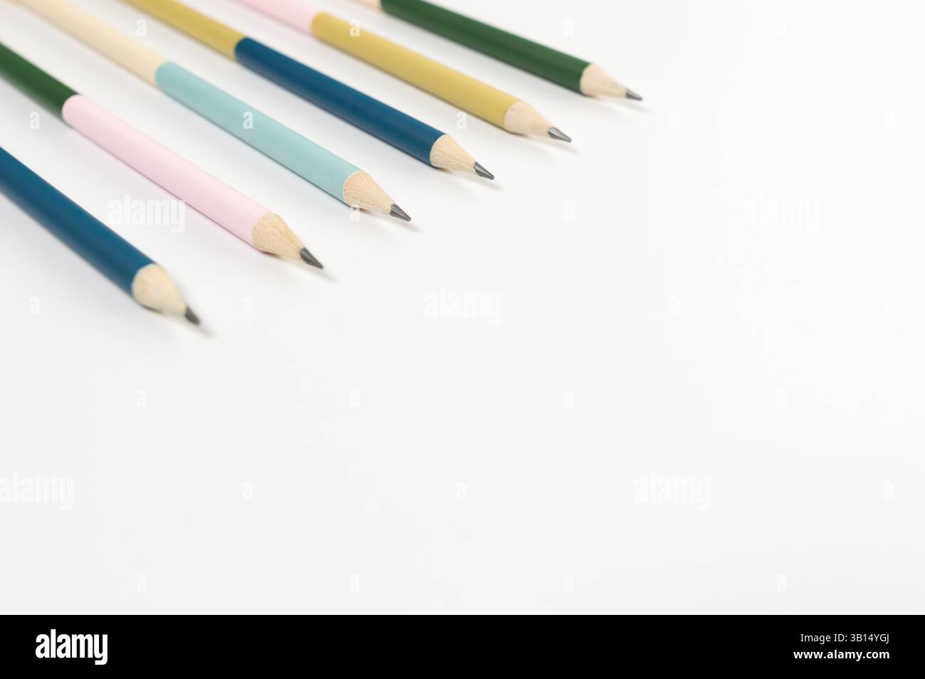 Vista dall'alto delle matite colorate su sfondo bianco. Scuola, ufficio, carta da parati. Disposizione piatta, spazio di copia. Foto Stock