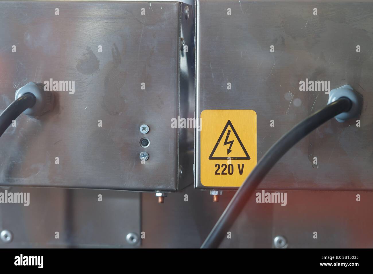 Apparecchiature elettriche che mostrano avvertenze di sicurezza presso un'officina Foto Stock