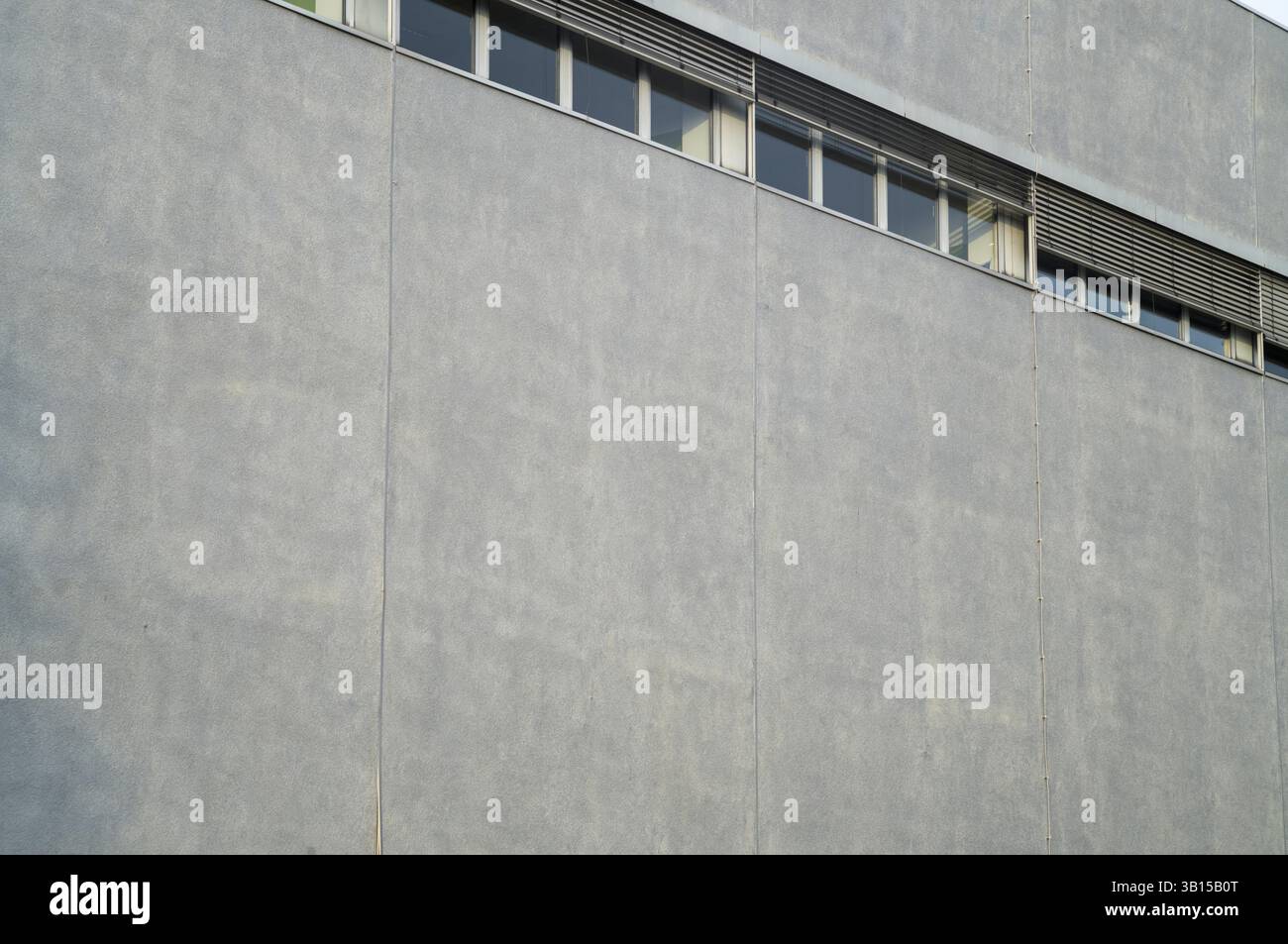 Muro di cemento di un edificio moderno con finestre e griglie di ventilazione, che mostrano architettura industriale, Borken, NRW, Germania, Europa Foto Stock