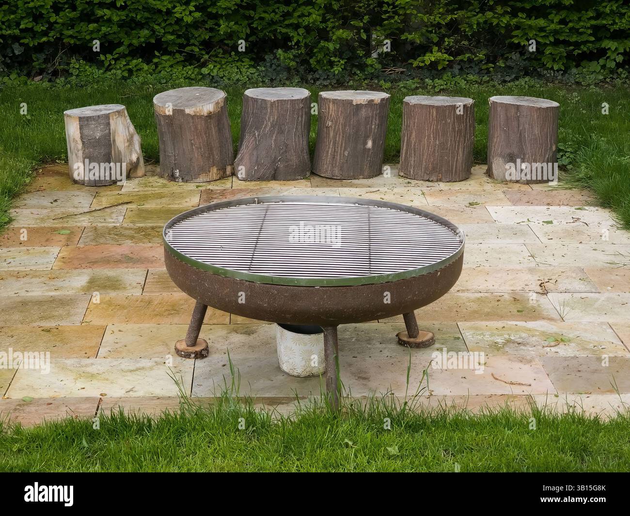 Area caminetto rustica all'aperto con posti a sedere in legno sul patio Foto Stock