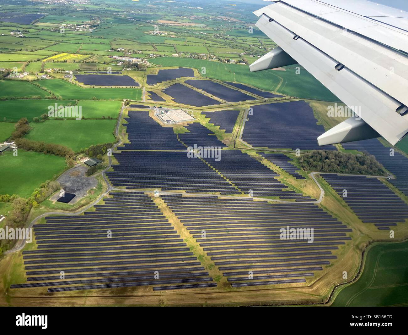 Pannelli a energia solare in un campo vicino all'aeroporto di Dublino visti dalla finestra dell'aereo di atterraggio. Foto Stock