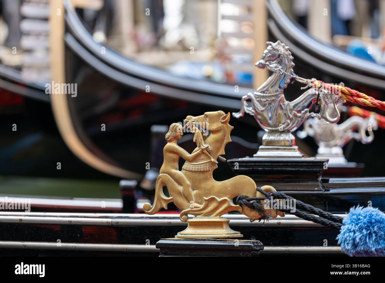 Figura decorativa a cavallo in oro e argento sulla gondola di Venezia con dettagli tradizionali e sfondo sfocato Foto Stock