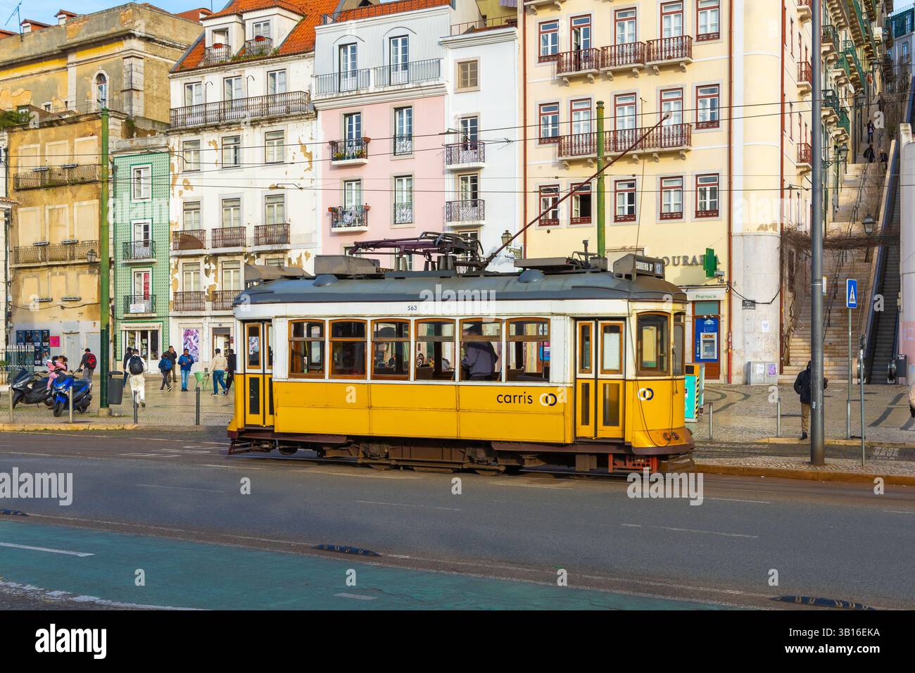 Vecchio tram giallo retro sulla strada di Lisbona, Portogallo. Scena di strada ed edifici colorati della citta' di Lisboa con tradizionale tram storico Foto Stock