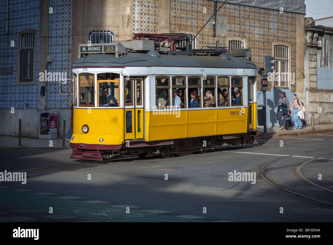 Tram giallo d'epoca sulla strada di Lisbona, Portogallo. Casa di sfondo con piastrelle. Foto Stock