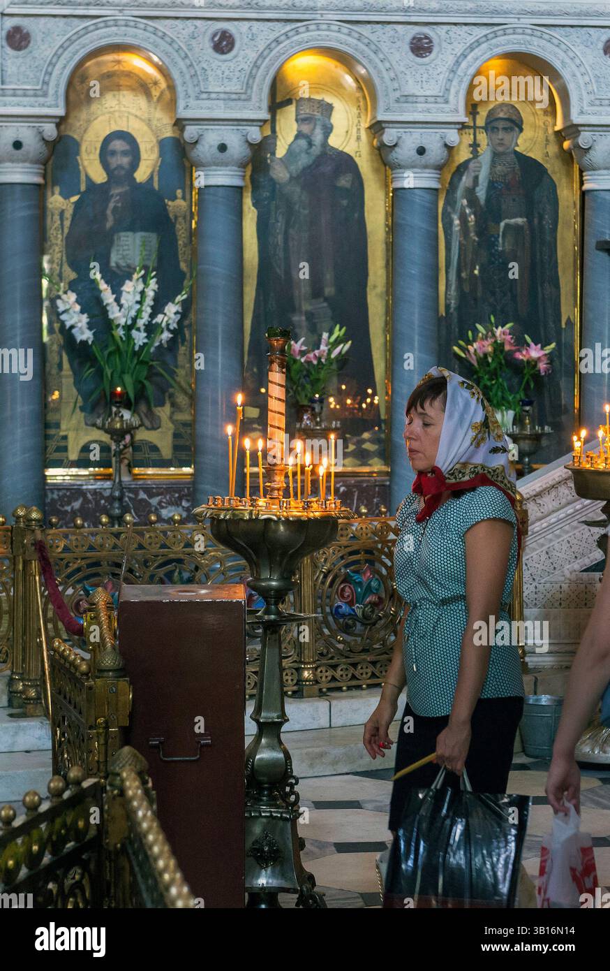 Un pellegrino prega nella Cattedrale di San Volodymyr è una cattedrale nel centro di Kiev. È uno dei principali monumenti della città e la cattedrale madre di Foto Stock