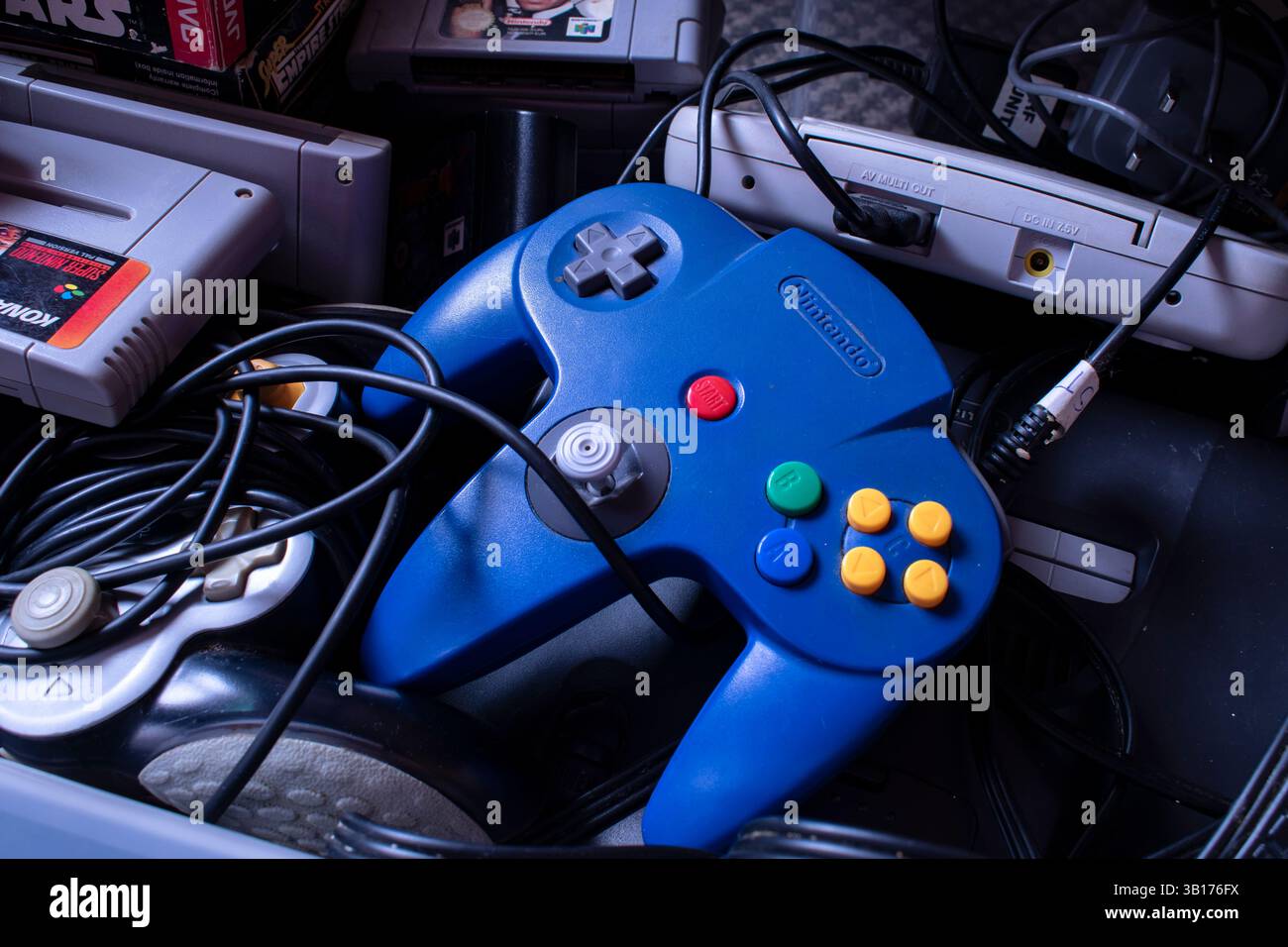 Contenitore con console Nintendo blu con cavi e varie cartucce di videogiochi; ripresa dall'alto Foto Stock