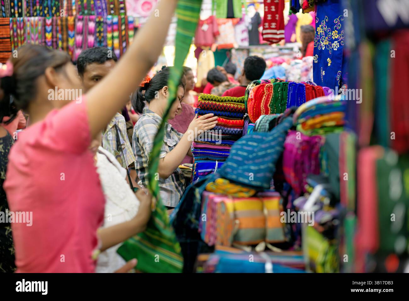 Betel lascia il mercato di Zegyo Mandalay Myanmar // MANDALAY, Myanmar — le foglie di Betel sono impilate con cura e disposte in un modello circolare presso la bancarella di un venditore nel mercato di Zegyo. Queste fresche foglie verdi del vitigno Piper betle servono da involucro per il liquido di betel (noto localmente come kun-ya), un leggero stimolante ampiamente consumato in Myanmar. La meticolosa disposizione riflette sia considerazioni pratiche per mantenere la freschezza che i valori estetici tradizionali negli schermi di mercato. I venditori di betel in genere vendono non solo le foglie, ma anche altri ingredienti necessari per la preparazione del liquido, inclusi Foto Stock