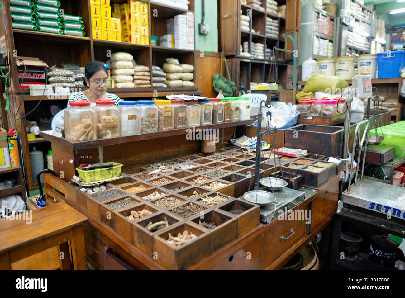 Erbe essiccate Medicina tradizionale mercato di Zegyo Mandalay Myanmar // MANDALAY, Myanmar — Un fornitore espone una varietà di erbe essiccate e medicinali tradizionali al mercato di Zegyo a Mandalay. Questi rimedi naturali rappresentano un aspetto importante del sistema sanitario tradizionale del Myanmar, che continua a prosperare insieme alla medicina moderna. L'assortimento comprende in genere piante secche, radici, cortecce e miscele preparate utilizzate per trattare vari disturbi secondo le tradizioni curative locali. Molti residenti del Myanmar si affidano ancora a questi rimedi tradizionali per problemi di salute comuni, in particolare nella zona Foto Stock