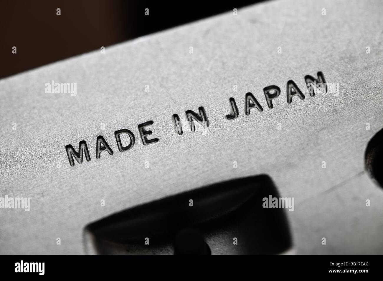 Le parole "MADE IN JAPAN" appaiono chiaramente incise sulla base in acciaio di una fotocamera d'epoca. Questo marchio rappresenta la significativa espansione industriale del Giappone dopo la seconda guerra mondiale, quando il paese sviluppò rapidamente i suoi settori di produzione ottica e di precisione. Le fotocamere giapponesi di quest'epoca sono diventate riconosciute a livello internazionale per la loro qualità e valore, contribuendo a stabilire il Giappone come potenza produttiva globale. Foto Stock