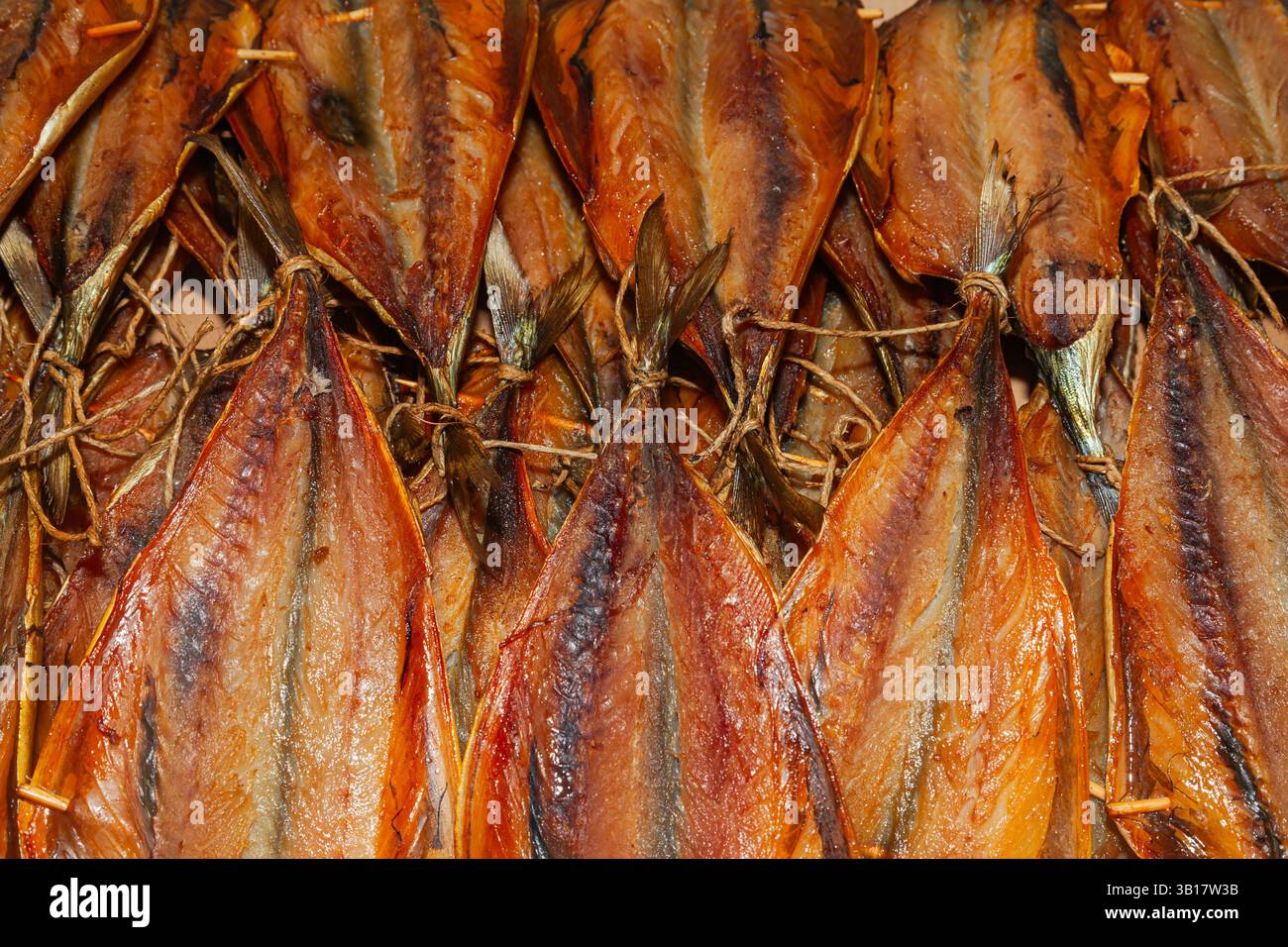 Primo piano di un lotto di pesce affumicato tagliato e finito. Foto Stock