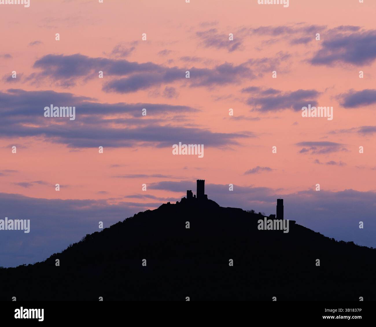 Le colorate e spettacolari nuvole del cielo dell'alba dietro la sagoma del castello di Hazmburk nelle Highlands boeme Foto Stock
