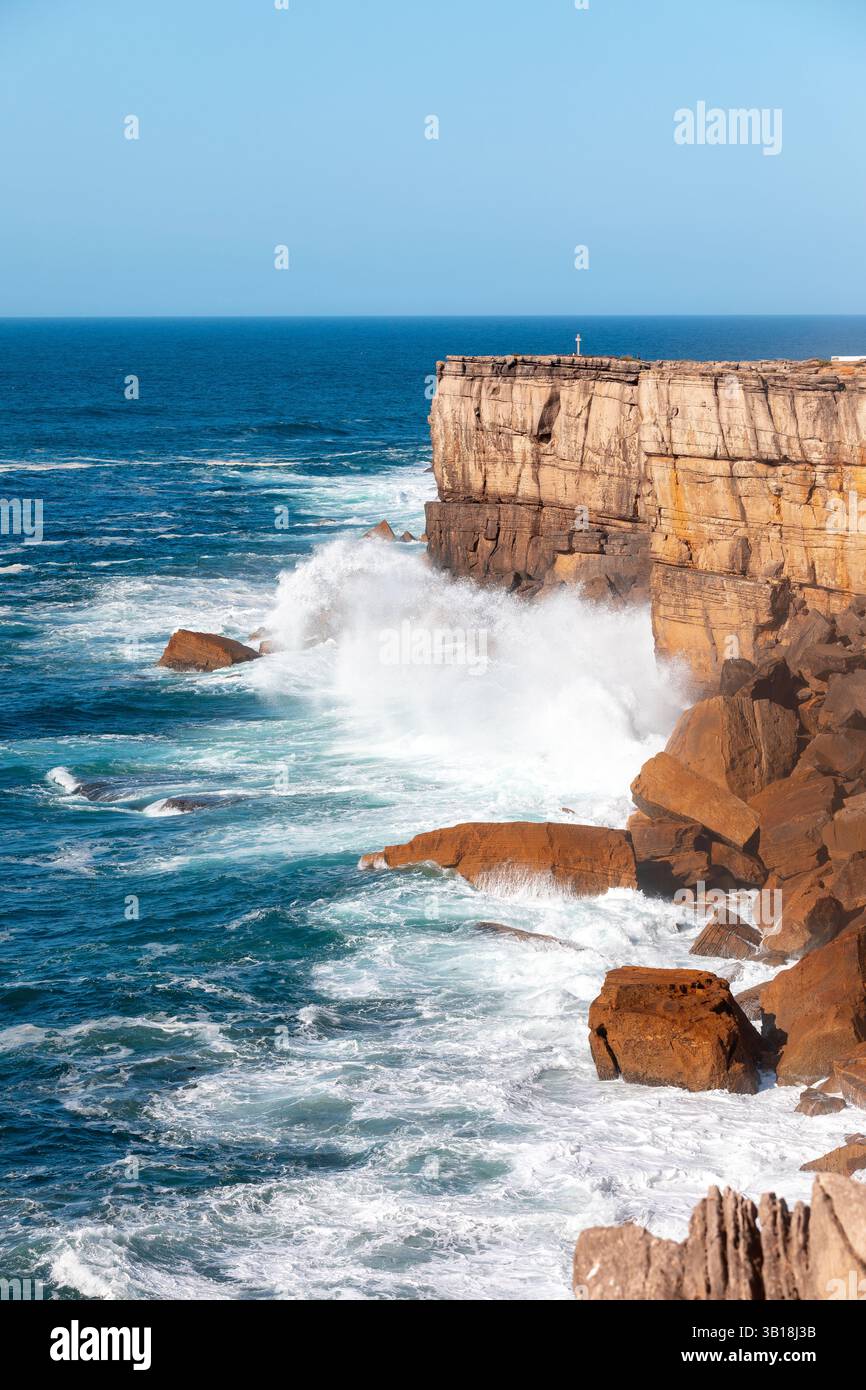 Costa rocciosa lungo la marginale Norte, Peniche, Portogallo, con onde che si infrangono contro la costa e un cielo azzurro limpido sulla costa atlantica. Foto Stock