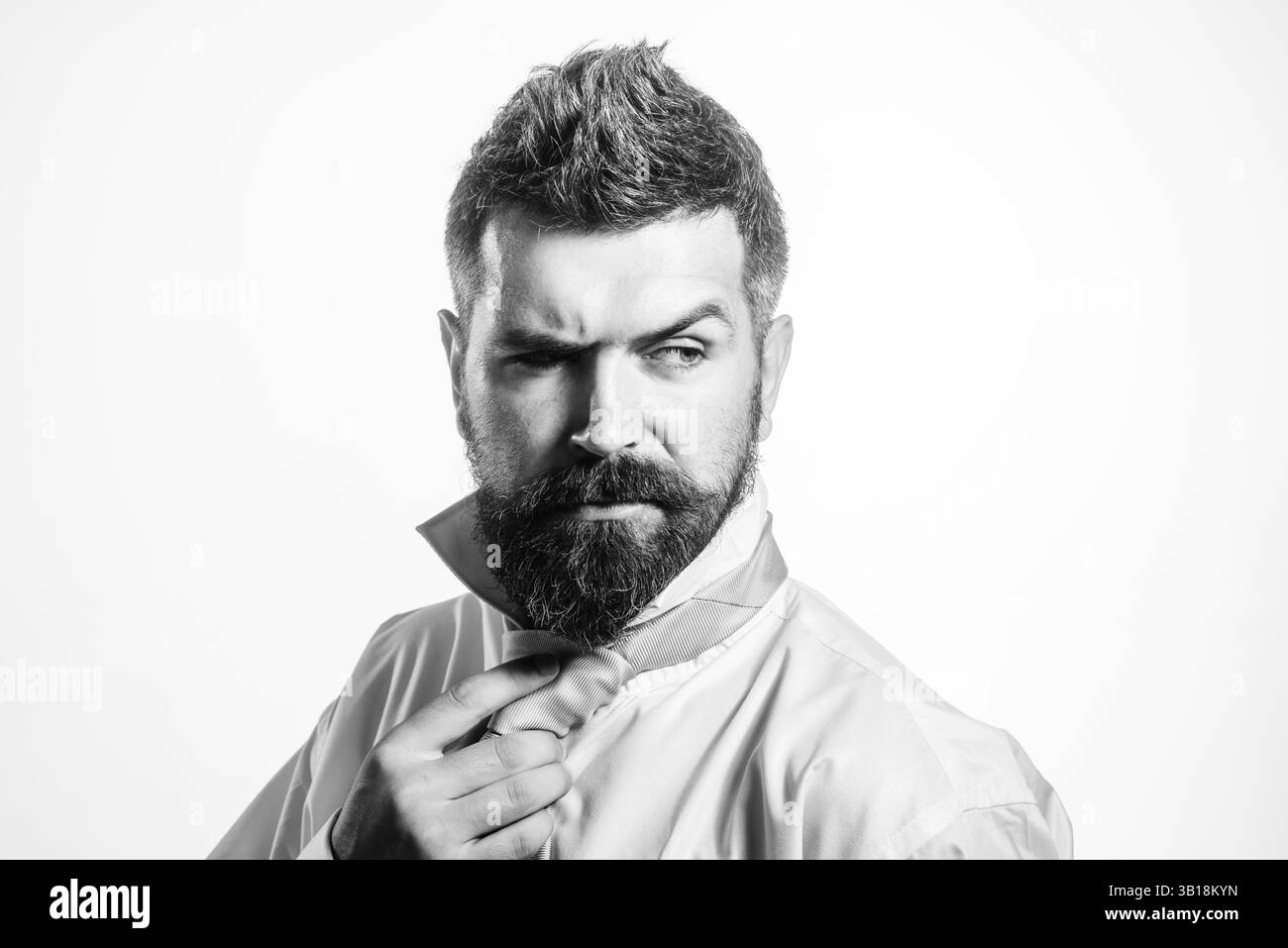 Bell'uomo con barba in camicia con cravatta regolabile sul collo. Uomo d'affari sicuro con cravatta da legare. Ritratto di un uomo d'affari di successo Foto Stock
