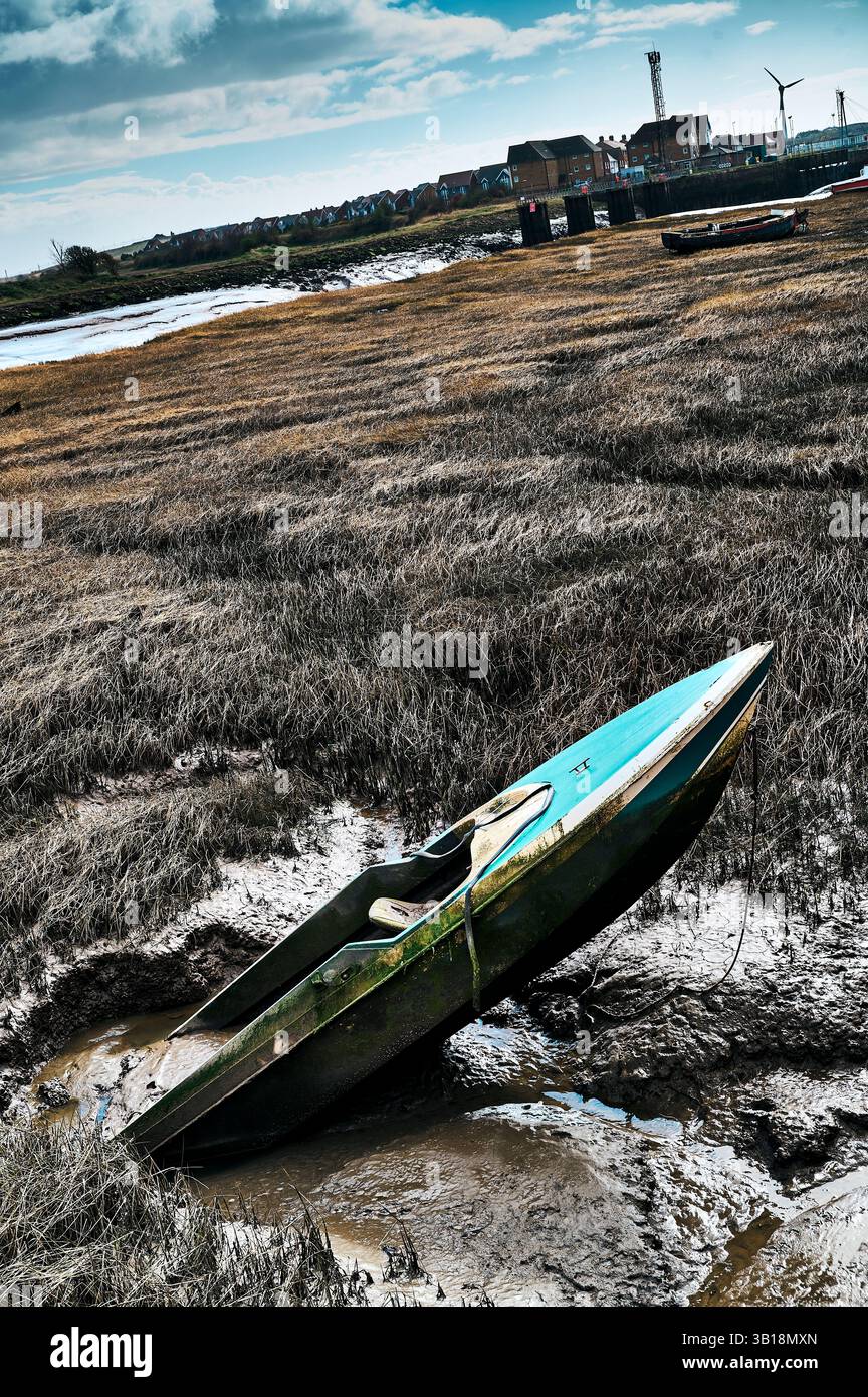 Una vecchia motoscafo che sporge dal fango in banchine insabbiate Foto Stock